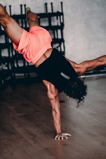 a man doing a handstand on a wooden floor